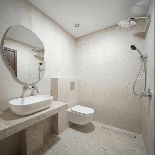 a bathroom with a sink and a toilet and a mirror at Golden Beach Apartment in Nea Moudania