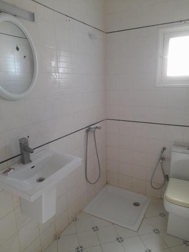 a white bathroom with a sink and a toilet at Taguermess Tag 5 in Taguermess