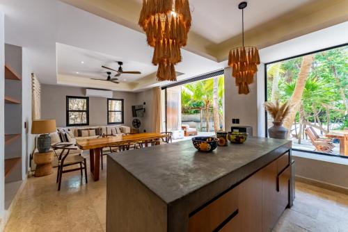 an open kitchen and dining room with a large island at Elements Rituals Beachfront Bahia Soliman Tulum in Tulum