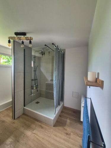 a shower with a glass door in a bathroom at Cocon moderne et chaleureux in Craon