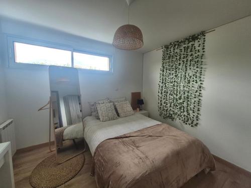 a bedroom with a bed and a window at Cocon moderne et chaleureux in Craon