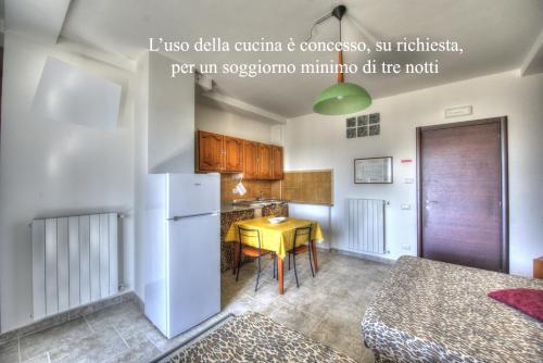 a kitchen with a yellow table and a white refrigerator at Casa Mastarna in Canino
