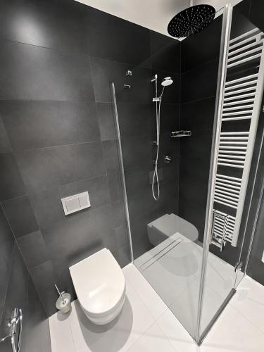 a black and white bathroom with a toilet and a shower at AH Terrace Jacuzzi Suite near Arena in Košice