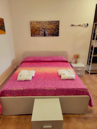 a bedroom with a bed with a pink bedspread at brezza marina in Siderno Marina