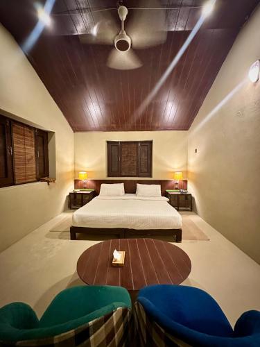 a bedroom with two beds and a table and two chairs at Sukoon Resorts Skardu in Skardu