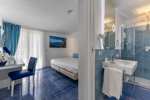 a bathroom with a bed and a sink and a shower at Hotel Metropole in Sorrento