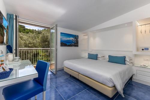 a bedroom with a bed and a desk and a window at Hotel Metropole in Sorrento