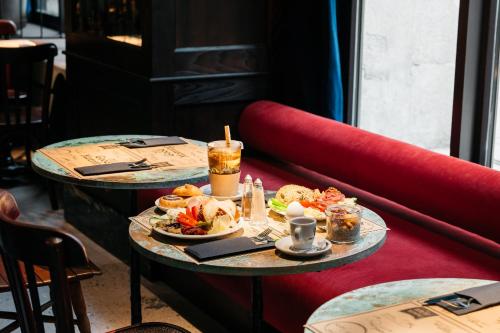 two tables with plates of food on them at Ruby Frida Hotel Stockholm by IHG in Stockholm