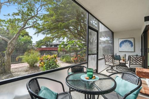 a balcony with a table and chairs and a large window at Park Shore Resort by Mike Z Rentals in Naples