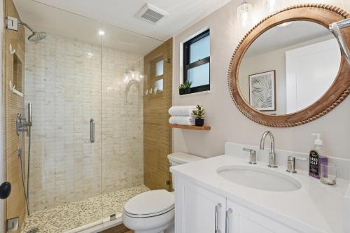 a bathroom with a toilet and a sink and a mirror at Park Shore Resort by Mike Z Rentals in Naples