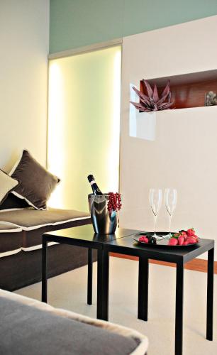 a living room with a table and two wine glasses at Cosmopolitan Hotel in Civitanova Marche
