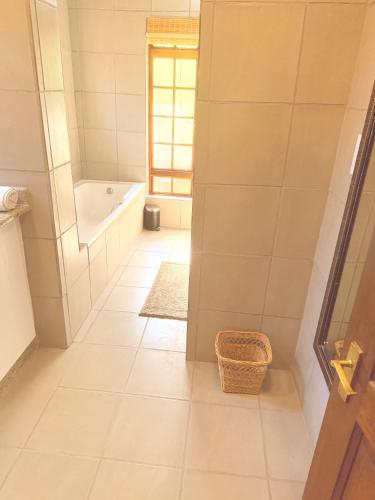 a white bathroom with a tub and a sink at Mabalingwe Mistykie Lodge in Warmbaths