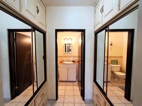 a bathroom with two doors and a sink and a toilet at Ocean Light at Villa Hermosa in San Carlos