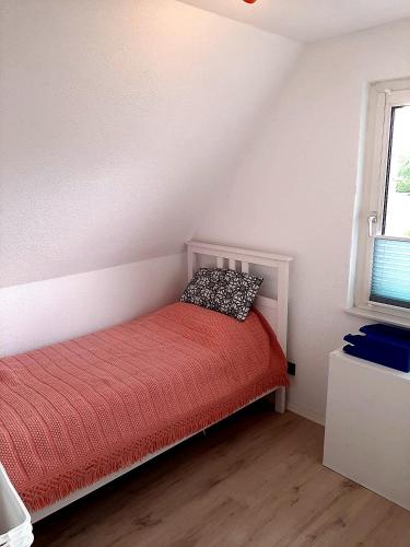 a small bedroom with a red bed with a pillow at Heide Nest Soltau in Soltau