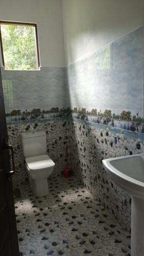 a bathroom with a toilet and a sink at The Papa Resort Ambuluwawa in Balatgomuwa