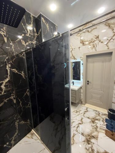 a bathroom with a shower with black marble at Grotto Resort & Restaurant in Quba