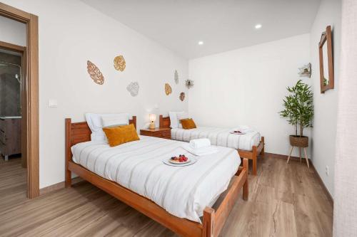 a bedroom with two beds with a plate of food on it at Stylish & Sleek Flat near the Beach by HostWise in Armação de Pêra