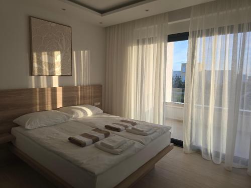 a bedroom with a large bed with towels on it at Villa Solis in Novalja