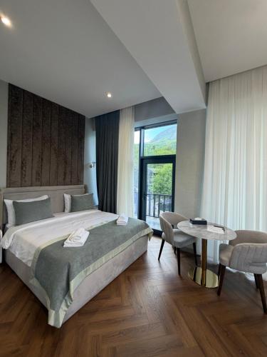 a bedroom with a large bed and a table at Grotto Resort & Restaurant in Quba