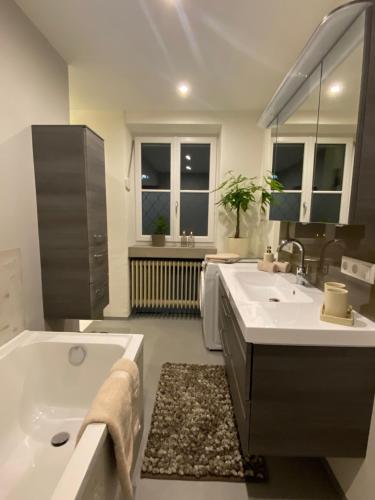 a bathroom with a tub and two sinks and a bath tub at Ferienwohnung Servus in Traunstein