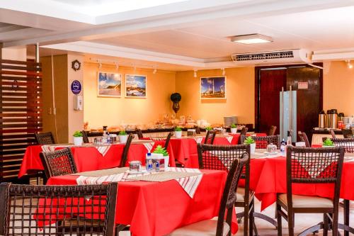 a dining room with red tables and chairs at Paradise Flat in Natal