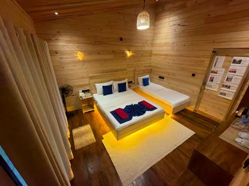 a bedroom with two beds in a wooden room at Wood Chalets Ella in Ella
