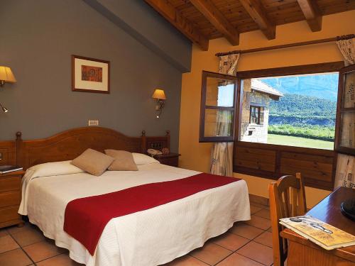 a bedroom with a bed and a large window at Hotel & SPA Peña Montañesa in Aínsa