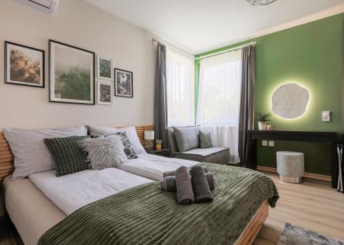 a bedroom with a large bed with green walls at Riverside Apartman**** Miskolc in Miskolc