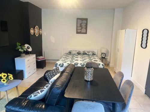 a bedroom with a bed and a table and a couch at Cocon de Tonnerre in Tonnerre