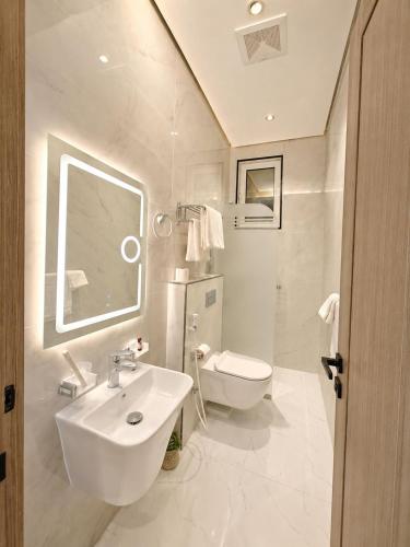 a white bathroom with a sink and a toilet at إليت إن - ELITE INN Serviced Apartments in Qal'at Bishah