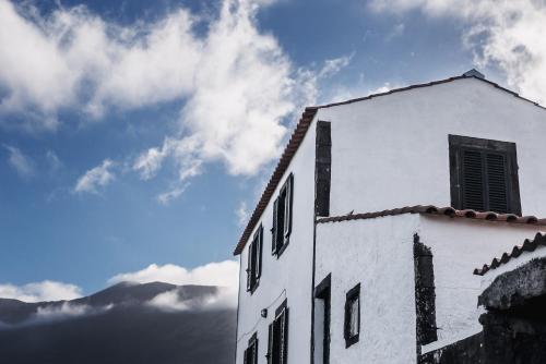 a white building with a window on top of it at Liiiving in Azores - Ocean View House in Canto da Areia