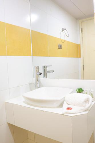 a bathroom with a white sink and a mirror at Hotel Paola Antofagasta in Antofagasta
