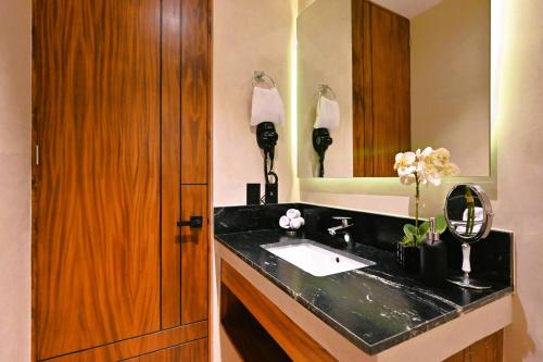 a bathroom with a black sink and a mirror at Swim up pool Beachclub rooftop in Tulum