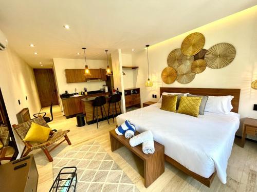 a bedroom with a large bed and a kitchen at Swim up pool Beachclub rooftop in Tulum