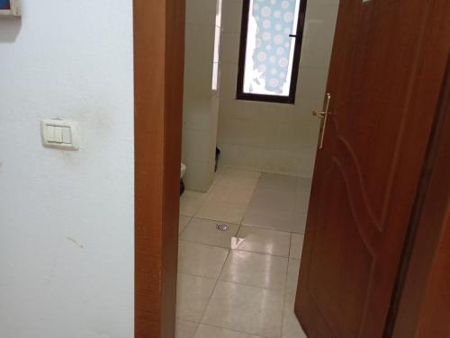 an open door to a bathroom with a tile floor at Enjoy Hostel in Tirana