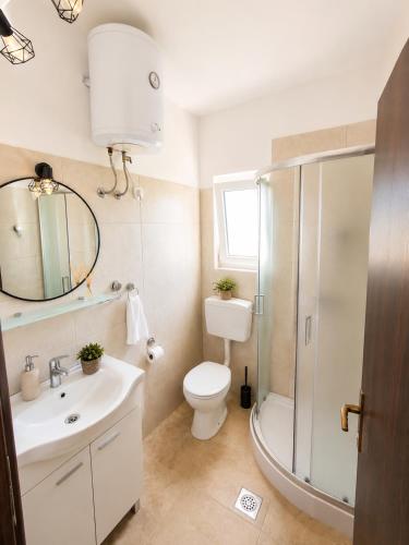 a bathroom with a toilet and a sink and a shower at Ap AS in Rogoznica
