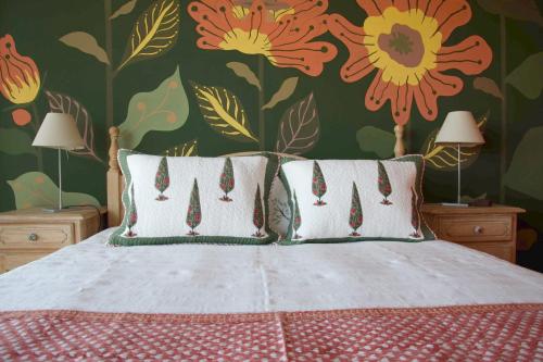 a bedroom with a bed with flowers on the wall at L'Effet Papillon - Maison d'hôtes in Sauges