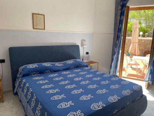 a bedroom with a bed with a blue comforter at La Vite in Ponza