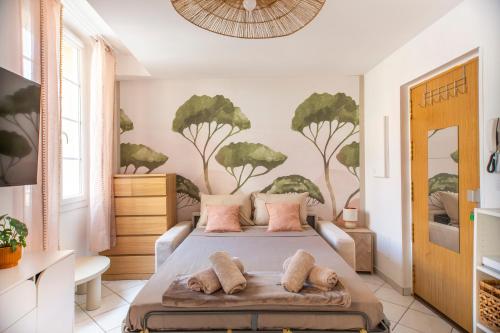 a bedroom with a bed and a painting of trees on the wall at Studio Equerre in Toulon