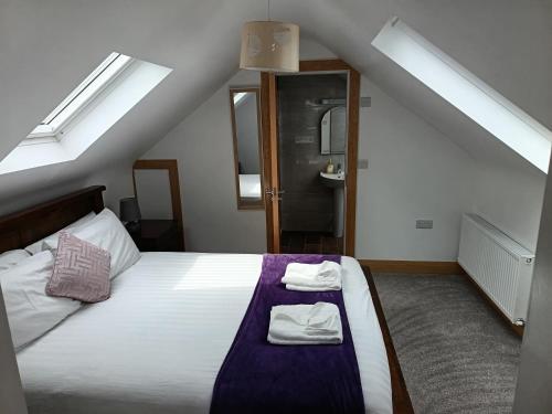 a bedroom with a bed with two towels on it at Radharc soiléir in Doolin