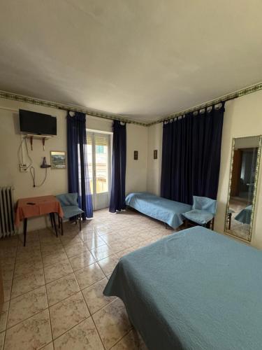 a hotel room with two beds and a mirror at Hotel Appennino in Sassoferrato