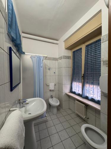 a white bathroom with a sink and a toilet at Hotel Appennino in Sassoferrato