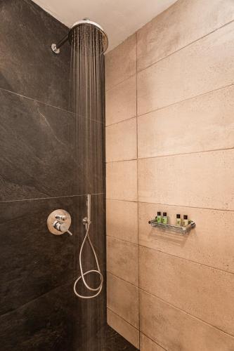 a shower with a shower head in a bathroom at Aurora Sky & Sea in Fira