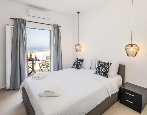 a bedroom with a bed with a view of the ocean at Aurora Sky & Sea in Fira
