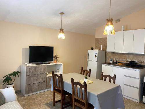 a kitchen and dining room with a table and a television at Casa Ayacucho in Alta Gracia