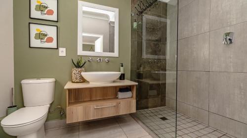 a bathroom with a toilet and a sink and a shower at Studio Bella Vista Plett in Plettenberg Bay