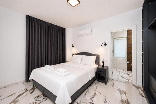 a bedroom with a white bed and a bathroom at Villa White Cloud in Dalyan