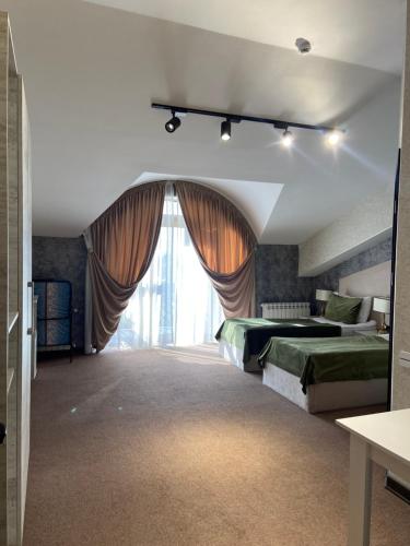 a bedroom with two beds and a large window at TALA ROOMS Hotel in Zaqatala