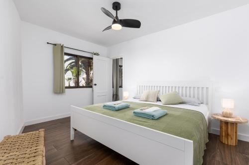 a white bedroom with a bed with two pillows on it at Casa Nube in Corralejo