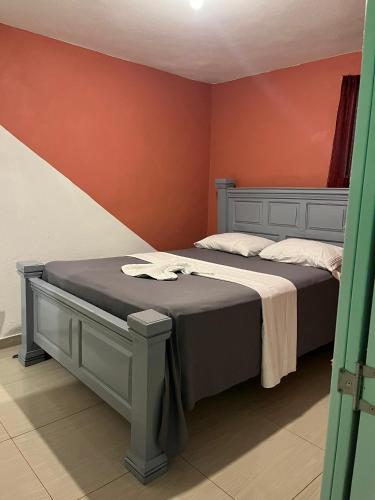 a bedroom with a bed and a red wall at BAYO HOTEl in Cap-Haïtien
